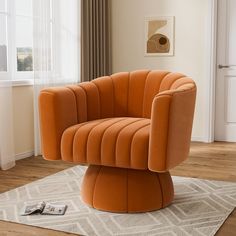 an orange chair sitting on top of a rug in a living room next to a window