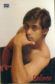 a man with no shirt is posing for the camera and has his hand on his head