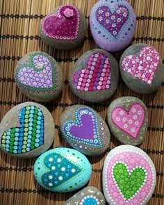 painted rocks with hearts on them sitting on a mat