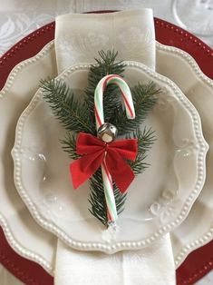 a white plate topped with candy canes and a christmas decoration on top of it