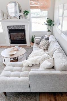 a living room filled with furniture and a fire place in front of a mirror on the wall