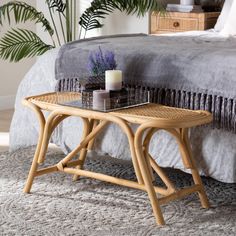 a wicker coffee table sitting on top of a carpeted floor next to a bed