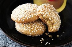 two sesame seed bagels on a black plate