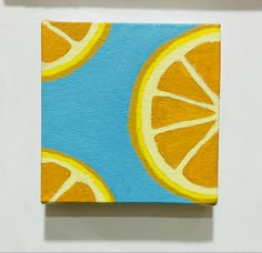 an orange slice on a blue and yellow background is featured in this small square painting