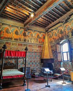 an ornate bedroom with intricately painted walls and ceiling, along with two large windows