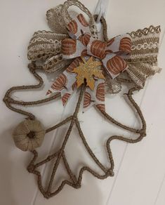 a decorative fall leaf made out of twine and burlap with an acorn ornament