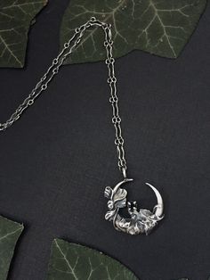 "Moon Garden | Art Nouveau, Crescent Moon Necklace, Antique Reproduction, Sterling Silver, Spinel, Oxidized, Witchy This lunar jewel, the first of my line of cast sterling silver moon metal jewels, is an ode to the beauty and romance of the Art Nouveau era that juxtaposes perfectly with Wyther's signature dark botanical aesthetic. Ivy leaves and vines with a flower in full bloom wind their way around this design. Cast from a 100+ year old antique brooch and modified to suit modern needs, including the addition of a basket setting that cradles within it a luminous 3mm Black Spinel faceted gemstone.  Moon measures 25mm or 1 inch approximately.  Individually cast and hand finished, with each protective black stone hand set by me. Intentionally made from solid sterling silver moon metal that h Dark Botanical Aesthetic, Witchy Necklaces, Botanical Aesthetic, Witchy Room, Moon Garden, Necklace Antique, Antique Brooches, Crescent Moon Necklace, Moon Jewelry