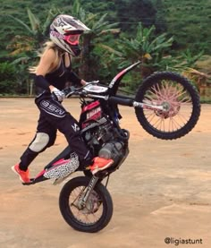 a person on a dirt bike doing a trick in the air with one foot up