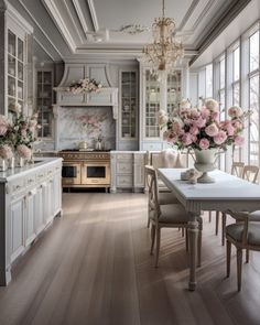 an elegant kitchen with white cabinets and pink flowers in vases on the dining room table