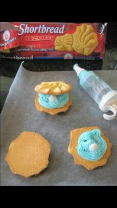 some cookies are sitting on a cookie sheet with icing next to the doughnuts