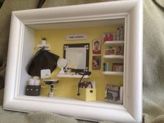 a white frame with a black umbrella and pictures on it in front of a yellow wall