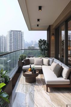 an outdoor living area with couches, tables and potted plants on the balcony