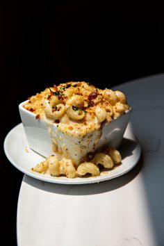 a white plate topped with macaroni and cheese casserole on top of a table