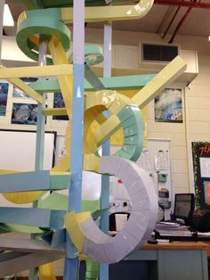 an office cubicle with a water slide in the center and lots of paper streamers hanging from the ceiling