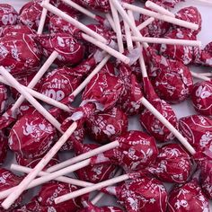 a pile of red and white lollipops sitting on top of each other