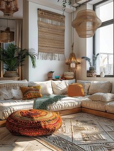 a living room filled with lots of furniture and hanging plants on the wall next to large windows