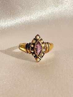 Antique 14k yellow gold Victorian style ring featuring a navette amethyst with ten pearls surrounding the central stone. Great antique condition Size: 7 resizable** Weight: 2.2 grams Band: 13.0 mm (front), 2.2 mm (back) Amethyst: 6.4 mm x 3.0 mm Pearls: 1.5 mm x 10 split cut Please note, vintage and antique jewelry may come with imperfections commensurate of their age. To see more photos and videos of this piece, visit our Instagram: www.instagram.com/23carat Victorian 14k Gold Amethyst Wedding Ring, Victorian Gold Amethyst Ring With Center Stone, Antique Gold 14k Gold Amethyst Ring, Antique 14k Gold Amethyst Ring, Victorian 14k Gold Amethyst Ring Collectible, Victorian Style Rings, Signet Ring, Victorian Fashion, Antique Jewelry