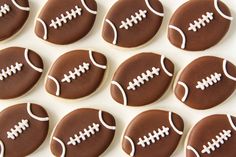 chocolate decorated cookies with white frosting and footballs on them are arranged in rows