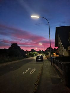 a car parked on the side of a road under a street light