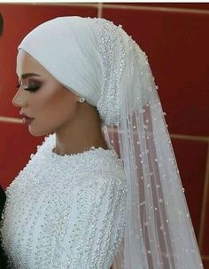 a man and woman are dressed up in wedding attire, one is wearing a veil