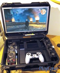 an open laptop computer sitting on top of a table with video game controllers in front of it