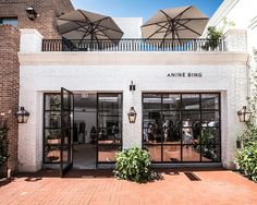 the front entrance to an apartment building with umbrellas