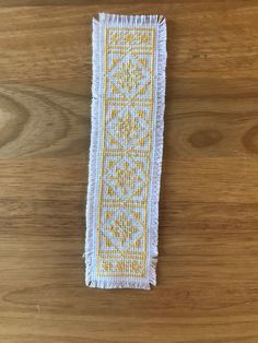 a yellow and white rug sitting on top of a wooden table