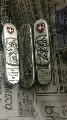 three silver lighters sitting next to each other on top of newspaper