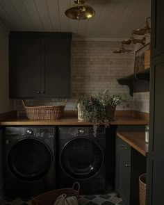 a washer and dryer sitting in a room next to a counter with baskets on it