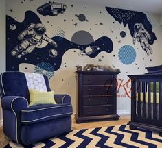 a baby's room with an astronaut theme painted on the wall