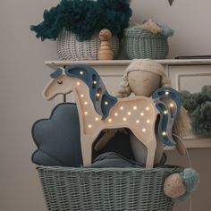 a toy horse sitting on top of a basket next to stuffed animals and other toys