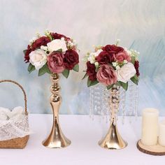 two vases with flowers and candles on a table