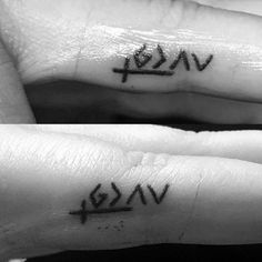 two small tattoos on the fingers that say love and piscripe, both with letters