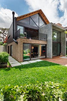 a modern house in the middle of a lush green yard