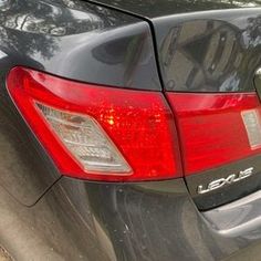 the back end of a black car parked in a parking lot