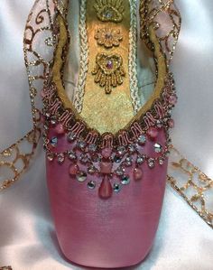 a close up of a shoe on a white surface with chains and beads around it