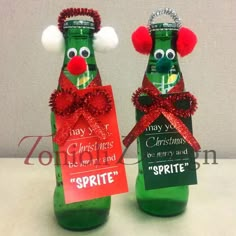 two green bottles decorated with red bows and christmas decorations, one has a sign that says spirit