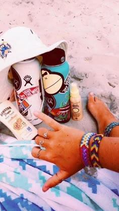 a person laying on the beach with sunscreen and other items