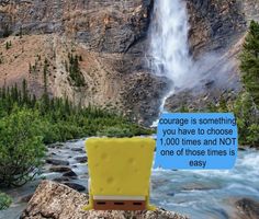 a spongebob sitting on top of a rock in front of a waterfall with a sign