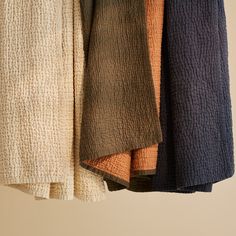 several towels hanging on a rack in a room with beige walls and white flooring