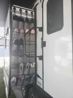 the inside of a travel trailer with shoes hanging from it's back door and shelves