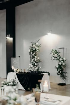 the table is set up with white flowers and greenery for an elegant wedding reception