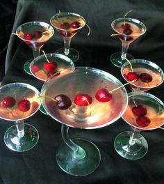 several martini glasses with cherries in them