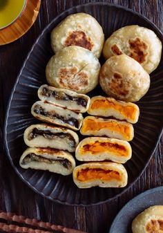 some food is sitting on a plate with chopsticks and a cup of tea