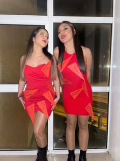 two women in red dresses standing next to each other