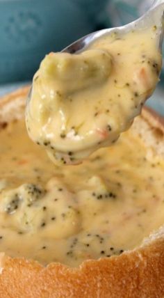 a spoonful of cheese sauce over a bread bowl