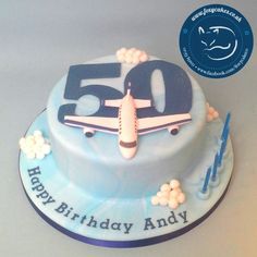 a blue birthday cake with an airplane on it's top and the number fifty