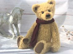 a brown teddy bear sitting next to a white horse