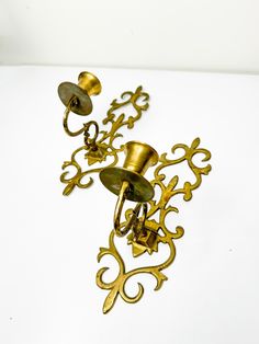 an antique brass wall light with two candle holders