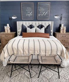 a bedroom with blue walls and two pictures above the bed